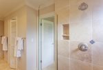 The bathroom features a large walk-in, tile shower
